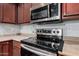 Stainless steel range and microwave in a kitchen with wood cabinets at 3621 W Glass Ln, Phoenix, AZ 85041