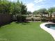 Artificial turf backyard with a pool and a view of the community at 3919 E Blue Sage Rd, Gilbert, AZ 85297