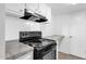 Black stove and oven with overhead range hood in galley kitchen at 5406 W Hearn Rd, Glendale, AZ 85306