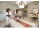 Bright dining room featuring a large table, chandelier, and decorative floral arrangement at 6416 W Parkside Ln, Glendale, AZ 85310