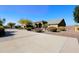 Long driveway leading to a tan house with landscaping at 6416 W Parkside Ln, Glendale, AZ 85310