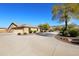 Tan house with tile roof, landscaping, and a long driveway at 6416 W Parkside Ln, Glendale, AZ 85310