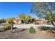 Tan house with tile roof, landscaping, and long driveway at 6416 W Parkside Ln, Glendale, AZ 85310