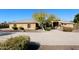 Tan house with tile roof, landscaping, and a long driveway at 6416 W Parkside Ln, Glendale, AZ 85310