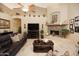 Living room features leather couches and stone fireplace at 6416 W Parkside Ln, Glendale, AZ 85310