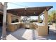 L-shaped outdoor kitchen under a pergola at 6416 W Parkside Ln, Glendale, AZ 85310