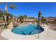 Relaxing pool with a waterfall, surrounded by palm trees and a patio area at 6416 W Parkside Ln, Glendale, AZ 85310