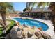 Freeform swimming pool with a rock water feature at 6416 W Parkside Ln, Glendale, AZ 85310