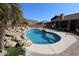 Inviting kidney-shaped pool with waterfall feature, surrounded by a spacious patio at 6416 W Parkside Ln, Glendale, AZ 85310