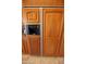 Built-in refrigerator with ice maker and wood paneling at 6416 W Parkside Ln, Glendale, AZ 85310