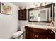 Charming bathroom featuring a dark wood vanity with a light countertop and decorative accents at 6422 W Garden Dr, Glendale, AZ 85304