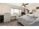 This bedroom features a ceiling fan, a large window with a view, built in shelving, and a large bed with a grey quilt at 6422 W Garden Dr, Glendale, AZ 85304