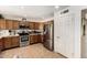 Efficient kitchen with stainless steel refrigerator, range, and plenty of cabinet storage at 6422 W Garden Dr, Glendale, AZ 85304