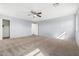 Spacious bedroom with neutral-colored carpet, ceiling fan, and freshly painted light blue walls at 7461 W Tumblewood Dr, Peoria, AZ 85382