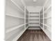 A walk-in closet featuring open white shelving along the walls and neutral-colored carpeting at 7461 W Tumblewood Dr, Peoria, AZ 85382