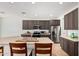 Open kitchen featuring tile floors, gray cabinets, island with sink and stainless appliances at 7461 W Tumblewood Dr, Peoria, AZ 85382