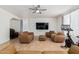 Cozy living room with tile flooring, ceiling fan, TV and brown leather furniture at 7461 W Tumblewood Dr, Peoria, AZ 85382