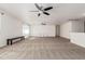 Large living room featuring neutral carpeting, ceiling fans, and white walls at 7461 W Tumblewood Dr, Peoria, AZ 85382