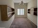 Bedroom with built-in shelving and large window with shutters at 7668 E Thunderhawk Rd, Scottsdale, AZ 85255