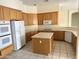 Kitchen with oak cabinets, island, and appliances at 7668 E Thunderhawk Rd, Scottsdale, AZ 85255