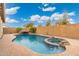 Inviting backyard oasis featuring a sparkling pool, spa, and waterfall feature at 7718 W Raymond St, Phoenix, AZ 85043