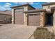 Home exterior with large carriage style garage doors and a paver driveway at 7718 W Raymond St, Phoenix, AZ 85043