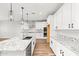 Modern kitchen with white cabinets, granite counters, and island at 7718 W Raymond St, Phoenix, AZ 85043