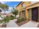 Tan two-story townhome with a walkway, landscaping, and a dark brown door at 7820 E Baseline Rd # 103, Mesa, AZ 85209