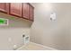 Laundry room with wooden cabinets and built-in shelving at 8827 W Dahlia Dr, Peoria, AZ 85381