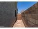 Side yard access with stone pathway and wooden gate at 8827 W Dahlia Dr, Peoria, AZ 85381