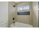 Updated bathroom with a tub and shower, stylish tile, and a window for natural light at 925 W Fairway Dr, Mesa, AZ 85201