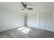 Spacious bedroom with grey carpet, double closets, and ceiling fan at 925 W Fairway Dr, Mesa, AZ 85201