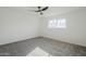 Bright bedroom featuring grey carpet, ceiling fan, and large window at 925 W Fairway Dr, Mesa, AZ 85201