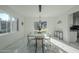 Modern dining room with glass table, white chairs, and marble floors at 925 W Fairway Dr, Mesa, AZ 85201