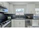 Modern kitchen with dark countertops and black and white backsplash at 925 W Fairway Dr, Mesa, AZ 85201