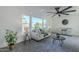 Living room with large windows, sofas, and a ceiling fan at 925 W Fairway Dr, Mesa, AZ 85201