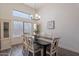 Bright dining room features a modern light fixture, large windows, and hardwood floors at 9325 E Fairfield St, Mesa, AZ 85207