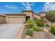 Single-story house with a two-car garage, landscaping, and American flag at 10834 W Swayback Pass, Peoria, AZ 85383