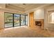 Living room with stone fireplace and access to patio at 10962 E Old Trails Rd, Scottsdale, AZ 85262