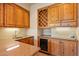 Wet bar with wood cabinets, granite countertop, wine cooler, and sink at 10962 E Old Trails Rd, Scottsdale, AZ 85262