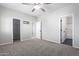 Well-lit bedroom featuring multiple closets and ceiling fan at 13185 W Calavar Rd, Surprise, AZ 85379