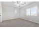 Bright bedroom with ceiling fan, carpet, and window with blinds at 13185 W Calavar Rd, Surprise, AZ 85379