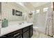 Bright bathroom featuring a single sink vanity with dark wood cabinets and a shower/tub combo with decorative curtain at 13235 W Tether Trl, Peoria, AZ 85383