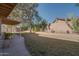 Landscaped backyard with a grassy area and covered patio at 14840 N 21St St, Phoenix, AZ 85022