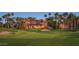 Picturesque clubhouse view with palm trees and golf course in the background at 14861 W Verde Ln, Goodyear, AZ 85395