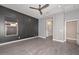 Spacious bedroom with gray walls, ceiling fan, and wood-look flooring at 16351 W Yucatan Dr, Surprise, AZ 85388