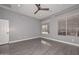 Well-lit bedroom with gray walls, wood-look flooring, and window coverings at 16351 W Yucatan Dr, Surprise, AZ 85388