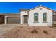 Single-story home with a two-car garage and desert landscaping at 17022 W Echo Ln, Waddell, AZ 85355