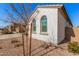 White stucco home with arched windows and a small tree at 17022 W Echo Ln, Waddell, AZ 85355