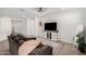 Living room with dark couch, large mirror, and a TV console at 17022 W Echo Ln, Waddell, AZ 85355